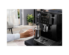 De'Longhi ECAM220.51.B Magnifica Start angled view frothing milk with the manual steam wand