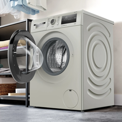 Bosch Series 4 washing machine in a modern laundry room with door open, loaded with laundry
