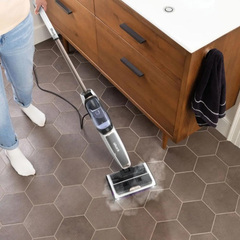 Shark SteamPickUp SD200ME steam mopping a bathroom tile floor near a wooden vanity