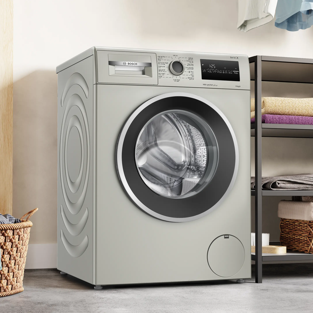 Bosch Series 4 washing machine styled in a laundry room next to a shelf of folded towels