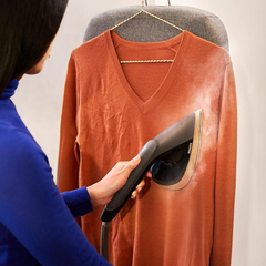 Philips AIS8540 garment steamer removing wrinkles from a sweater on a hanger