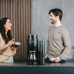 Melitta Aromafresh X Pro filter coffee machine styled on a kitchen counter with two people enjoying coffee